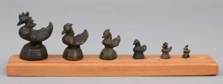 <b>Sechs Opium-Gewichte auf Holzbrett montiert</b>